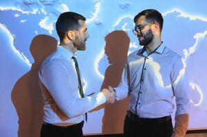 Handshake with map of the world in background photo