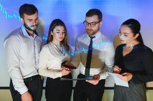 Group of business people working at modern office.Technical price graph, red and blue candlestick chart and stock trading computer screen background. Double exposure. Traders analyzing data photo