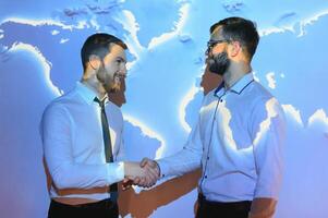 Handshake with map of the world in background photo