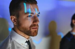 Stock Market Trader Working Investment Charts, Graphs, Ticker, Diagrams Projected on His Face. Financial Analyst and Digital Businessman Selling Shorts and Buying Longs photo
