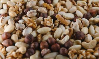 mixed nuts in a bowl on wooden table, top view with copy space. photo