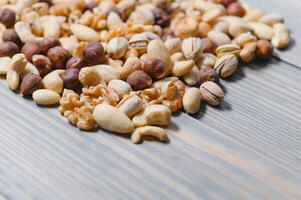 mixed nuts in a bowl on wooden table, top view with copy space. photo