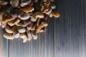 Mixed nuts on wood floor. Organic and fresh nuts. Copy space photo