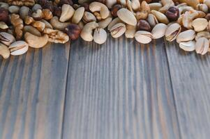 mixed nuts in a bowl on wooden table, top view with copy space. photo
