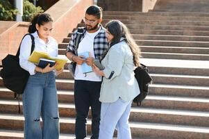 Portrait of three multi-ethnic university students embracing together standing in the campus photo