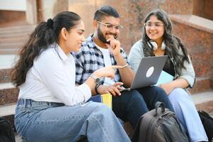 group of young students checking exam results or waiting for project approval on laptop at collage campus photo