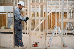 Worker carpenter assembling a modular house photo