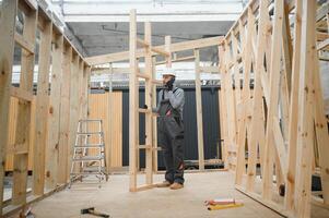 Process of construction new and modern modular house. Worker man in special protective uniform wear working on building development industry of energy efficient property photo