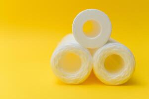 cartridges for water purification on a yellow background. Concept of clean water at home photo