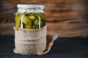 Pickled cucumbers in the jar. Ingredients for pickling cucumbers. Cucumbers, dill, garlic. Glass jars with pickles photo
