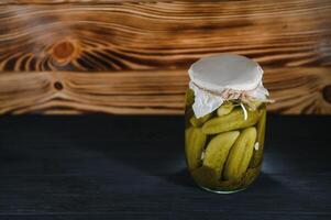 Pickled cucumbers in the jar. Ingredients for pickling cucumbers. Cucumbers, dill, garlic. Glass jars with pickles photo