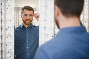 Man evaluating quality of glasses in optical shop photo