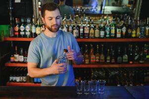 Handsome bar tender standing behind his counter in a pub photo