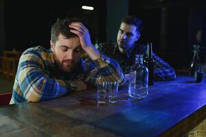 Sad man sitting at bar counter, alcohol addiction photo
