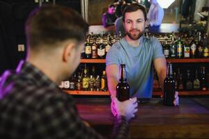 Portrait Of Smiling Male Bar Owner Standing Behind Counter photo