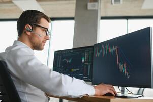 Serious business man trader analyst looking at computer monitor, investor broker analyzing indexes, financial chart trading online investment data on cryptocurrency stock market graph on pc screen. photo