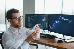 Successful trader in formalwear checking cryptocurrency information data on finance market graph, working in office photo