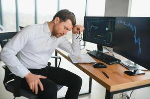 Successful trader in formalwear checking cryptocurrency information data on finance market graph, working in office photo