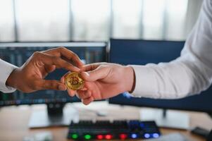 View of hand holding a bitcoin and giving it to other people. Cryptocurrency trading concept photo