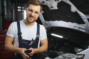 Portrait of a smiling fixing a car engine in his garage photo