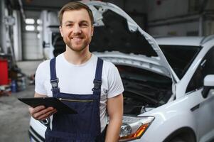 Automobile computer diagnosis. Car mechanic repairer looks for engine failure on diagnostics equipment in vehicle service workshop photo