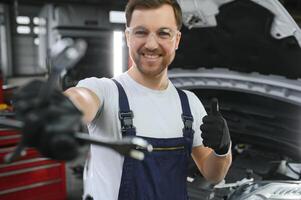 Portrait of a smiling fixing a car engine in his garage photo