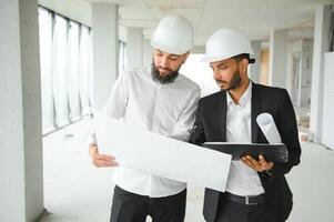 Construction concept of multiracial Engineer and Architect working at Construction Site with blue print photo