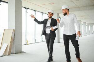 Happy workers at construction site, young civil engineer manager and architects. Indian and Arabian engineers. photo