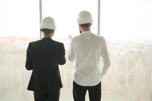 Construction concept of multiracial Engineer and Architect working at Construction Site with blue print photo