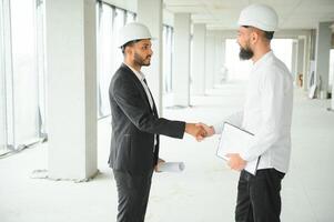 Construction concept of multiracial Engineer and Architect working at Construction Site with blue print photo