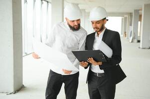 Construction concept of multiracial Engineer and Architect working at Construction Site with blue print photo