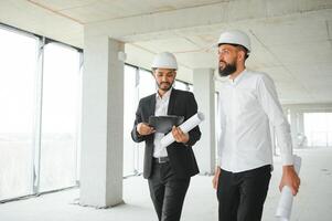 Construction concept of multiracial Engineer and Architect working at Construction Site with blue print photo