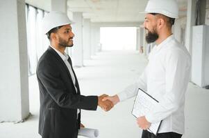 Construction concept of multiracial Engineer and Architect working at Construction Site with blue print photo