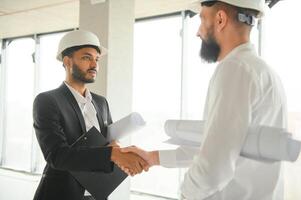 Construction concept of multiracial Engineer and Architect working at Construction Site with blue print photo