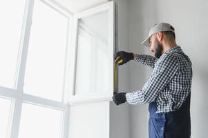 Construction worker installing window in house photo