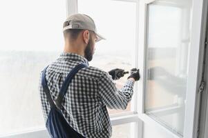 Worker installing plastic window indoors photo