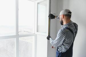 Construction worker installing window in house photo