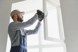 Construction worker installing window in house photo
