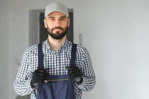 Laughing construction worker on the background of a gray concrete wall. Renovation. place for text photo