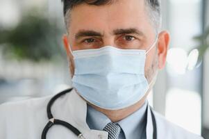 Senior in a hall. Doctor in a uniform. Man in a glasses. photo