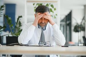 Senior caucasian man wearing doctor uniform and stethoscope at the clinic rubbing eyes for fatigue and headache, sleepy and tired expression. vision problem photo