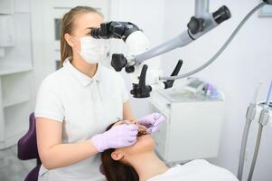 professional dentist examination patient with microscope at the office photo