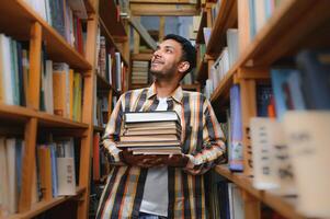 Happy smart indian or arabian guy, mixed race male, university student, in the library photo