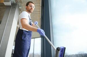 An employee of a professional cleaning service washes the glass of the windows of the building. Showcase cleaning for shops and businesses. photo