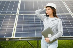 mujer ingeniero en casco en construcción sitio de solar poder planta. acuerdo concepto foto