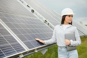 mujer ingeniero en casco en construcción sitio de solar poder planta. acuerdo concepto foto