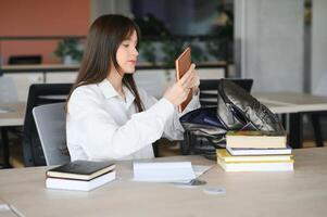 Teen girl studying with textbook writing essay learning in classroom. photo