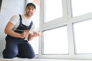 Construction worker installing window in house photo