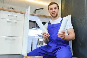 Plumber working change cartridge filter for water in kitchen. Concept filtration system. photo