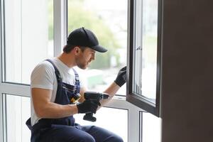 service man installing window with measure tape photo